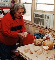 Anna Mitchell displays her clay stamps she uses to mark her pottery. 